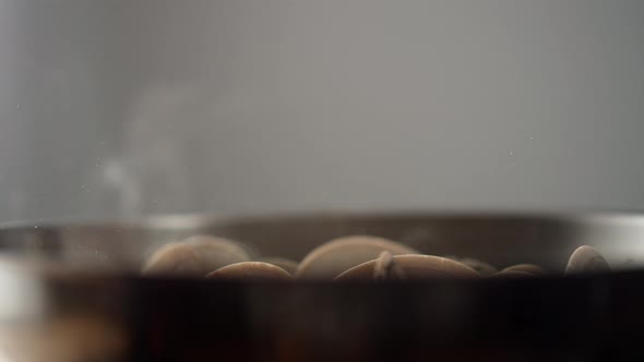 Camera follows adding pasta on cooked clams in a pan. Slow Motion. alt