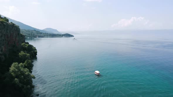 Aerial shot of Macedonia coast. Clif , boat and beautiful water around Ohrid Lake in Southern Europe