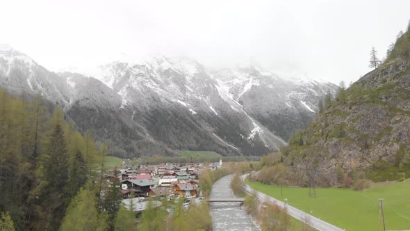 aerial footage of a small town with a river in the austrian alps - Sölden, Austria - drone