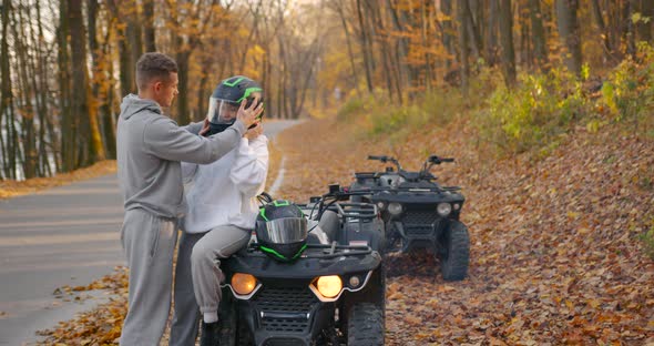 A Young Couple Rides an ATV Offroad in the Autumn Forest