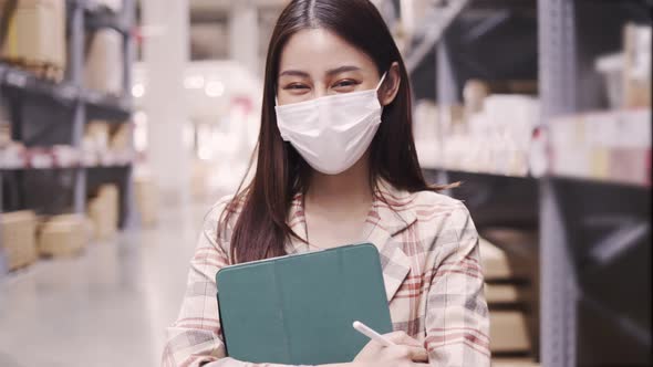 Portrait of smiling asian manager worker woman standing and order details on tablet