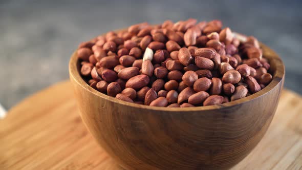 Raw Peanuts in small wooden bowl on natural gray rustic desk Video 4k