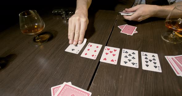 Poker game with a cowboy, cards, gun and whiskey on the table, 4k