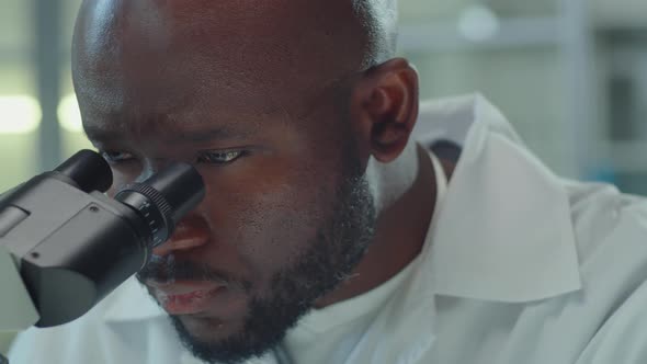 African American Lab Worker Using Microscope