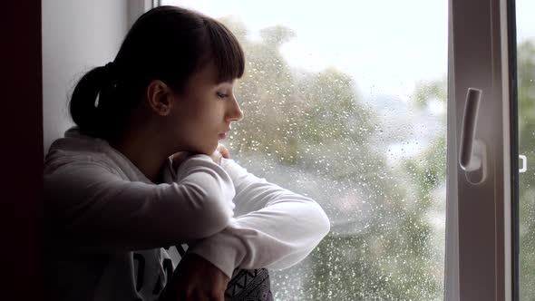 Sad Woman Sitting on Window