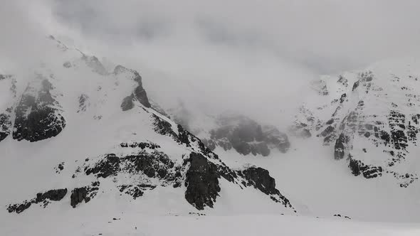 High Altitude Rocky Snowy Mountain Walls in Overcast Winter Day