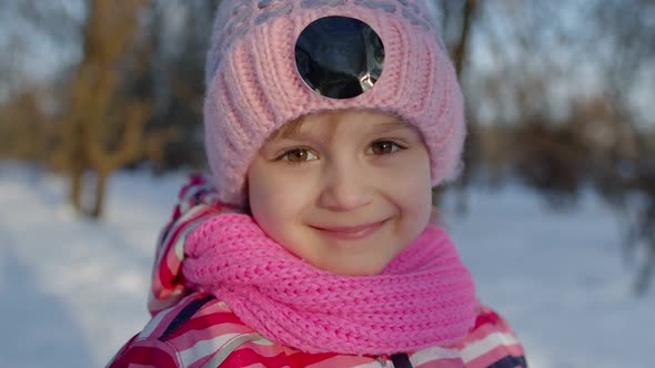 Child Girl Walking on Snowy Road Fooling Around Smiling Looking at Camera in Winter Park Forest