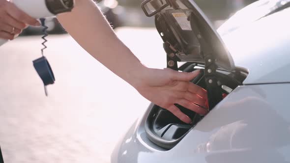 Connecting an electric vehicle to a charging station, putting a charger in hybrid car, sustainable t