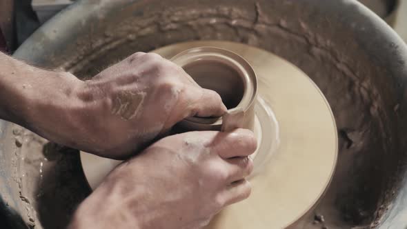 Hands of the Master Potter and Vase of Clay on the Potter's Wheel Closeup