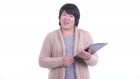 Happy Overweight Asian Woman Interviewing with Clipboard Ready for Winter