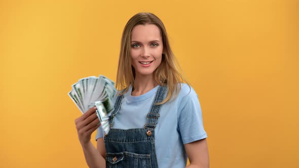 Portrait Smiling Woman Waving Cash Money Dollar Fan Salary Income Wealth Posing Isolated on Orange