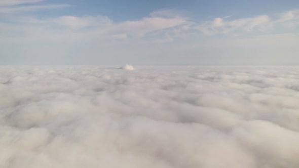 Aerial footage of flight over white puffy clouds