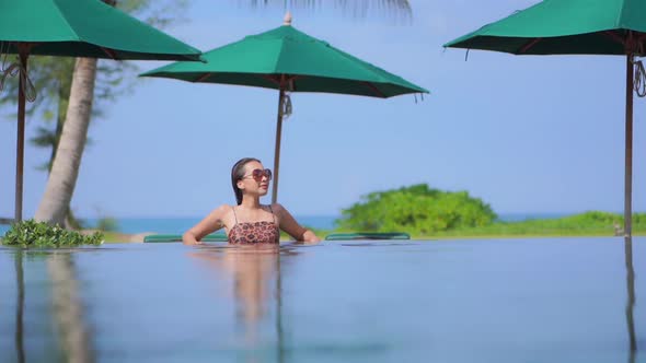 Young asian woman enjoy around outdoor swimming pool for leisure