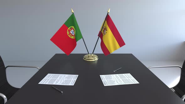 Flags of Portugal and Spain and Papers on the Table