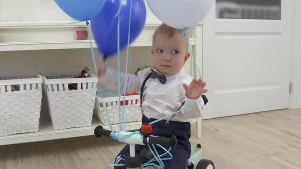 Kid on Baby Bicycle Balance Bike for Toddlers with Colorful Balloons 1 Year Old Baby Boy Celebrating