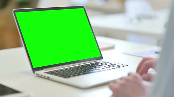 Rear View of Young Man Using Laptop with Chroma Screen