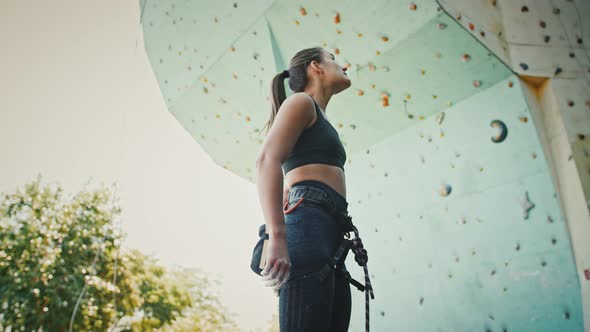 Young Woman Climber Flicks Excess Magnesium Off Her Fingertips Before Outdoor Climbing Practice