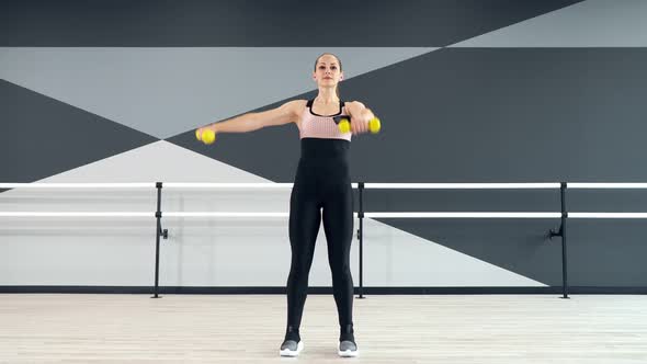 Woman Training Shoulders Using Dumbbells
