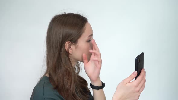 Woman is Reflected on the Screen of Her Mobile Phone