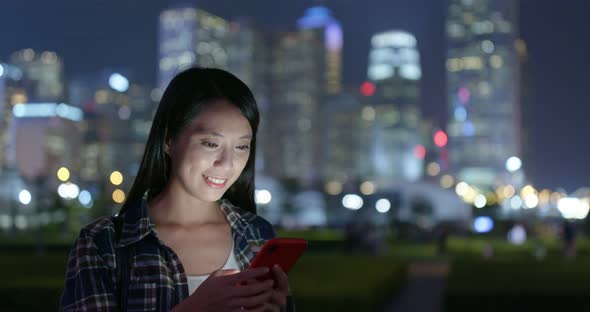 Woman check on mobile phone at outdoor in city at night