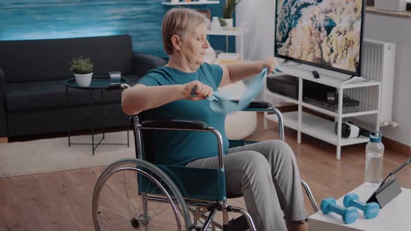 Person Sitting in Wheelchair and Pulling Resistance Band to Stretch