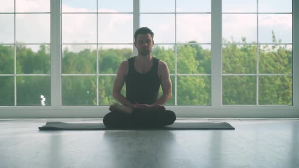 Wellness Young Man Does Yoga and Meditates a Calm Mood Relaxing in a White Room Filled with Light