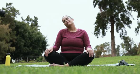 Young curvy woman doing yoga exercise outdoor