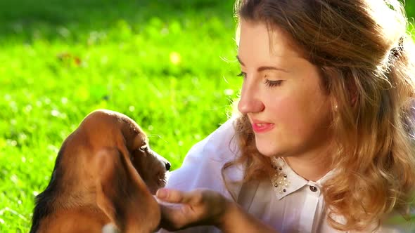 Happy Woman with a Dog Beagle Playing on Nature. Close Up