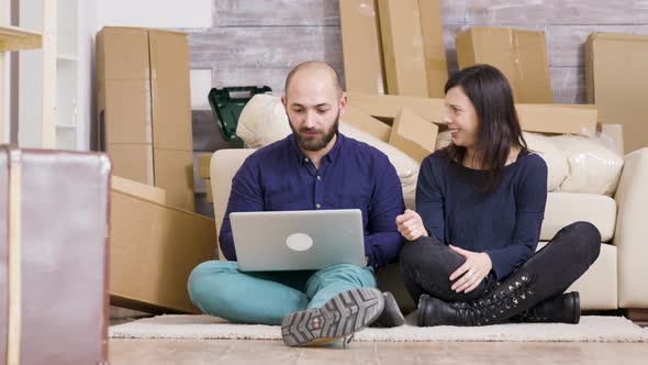 Couple in Their 30s Sitting on the Floor of Their New Flat