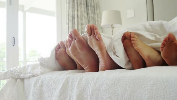 Family lying together in bedroom at home 