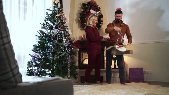 Joyful Caucasian Man and Woman Having Fun at Home on New Year's Eve. Husband and Wife Hanging