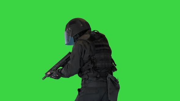 Masked Armed SWAT Police Officer Walking and Aiming with Rifle on a Green Screen Chroma Key