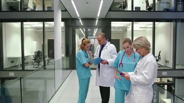 Doctors discussing over medical report in corridor