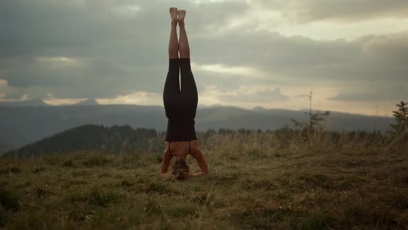 Girl Standing on Head in Mountain Landscape