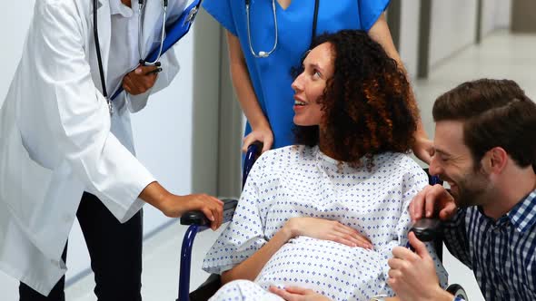 Doctor interacting with pregnant woman in corridor