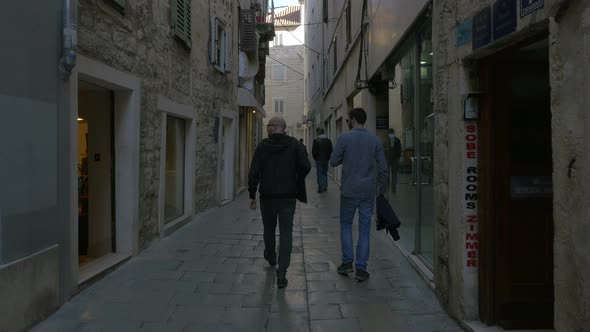 People walking on a narrow street 