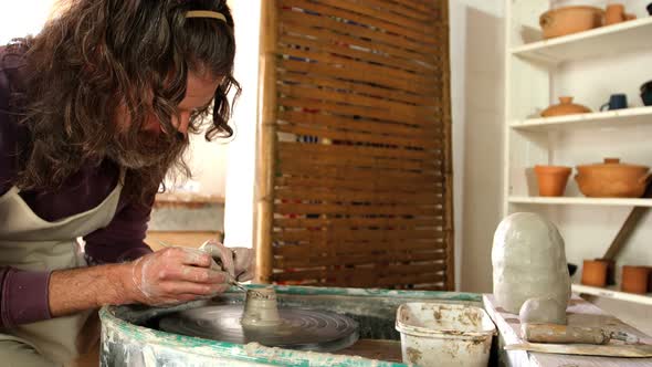 Male potter making pot