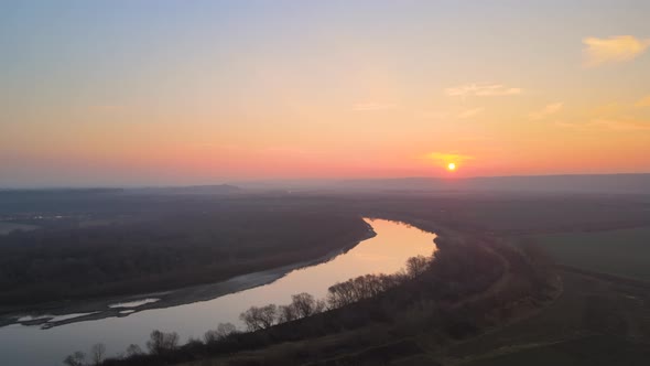 Aerial View of Wide River Flowing Quietly in Rural Countryside in Autumn Evening