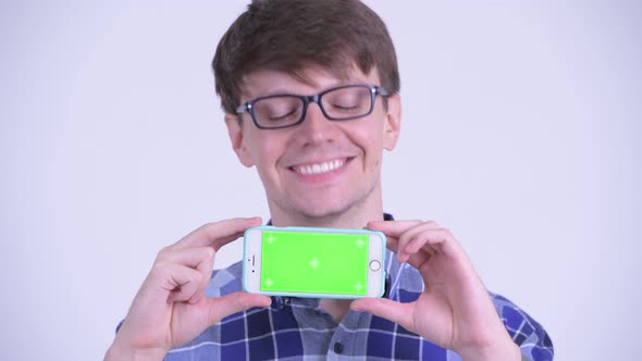 Face of Happy Young Handsome Hipster Man Showing Phone
