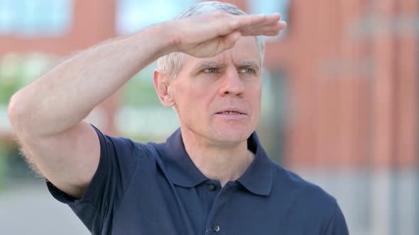 Outdoor Portrait of Focused Middle Aged Man Try To Look Far