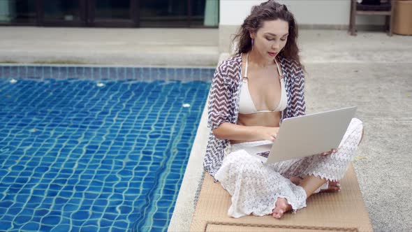 Female Tourist Using Laptop on Lounger