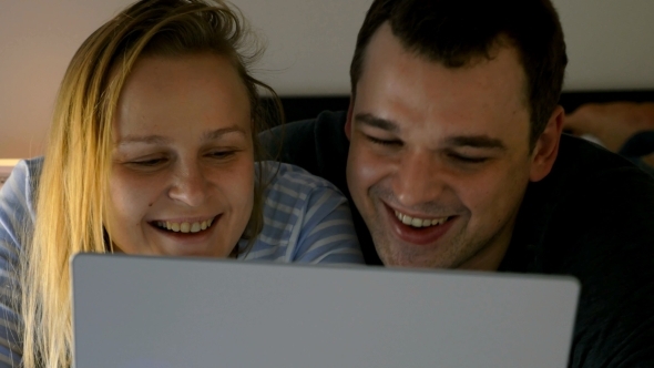 Couple Watching Humorous Video On Laptop