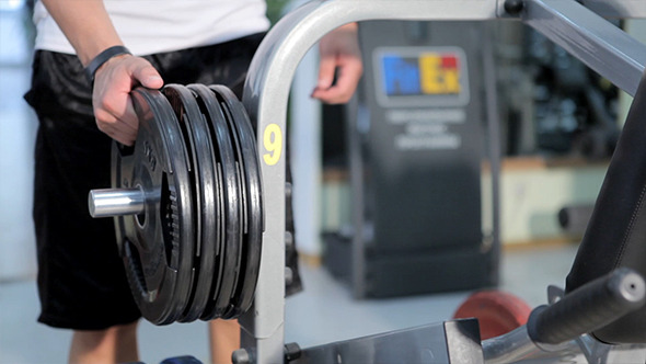 Men Placing Weights In Gym