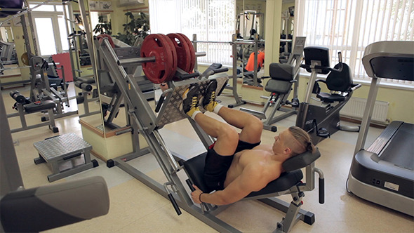 Bodybuilder Pushing Weights With Legs