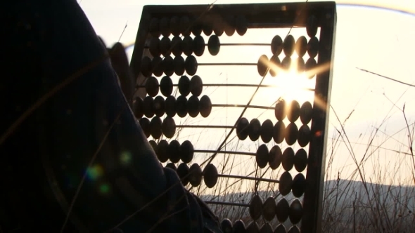 Woman In Black Moving Beads On Abacus At Nature