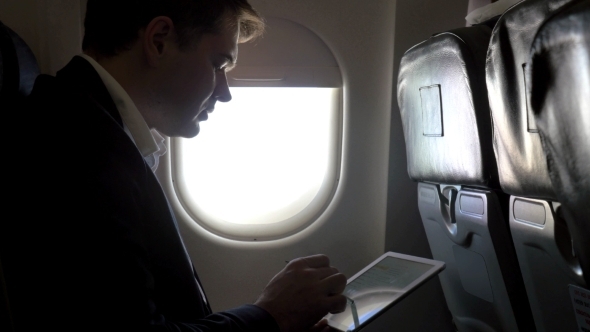 Young Businessman Working With Pad In Plane
