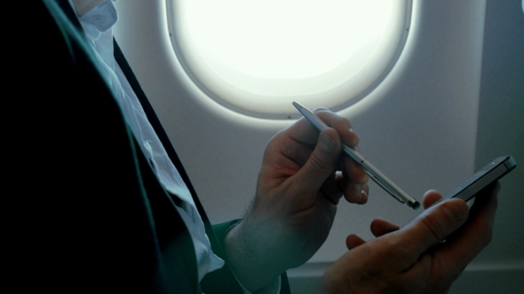 Businessman Using Smart Phone During The Flight