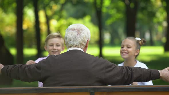 Cheerful Grandchildren Running to Their Beloved Grandfather, Hugging Back View