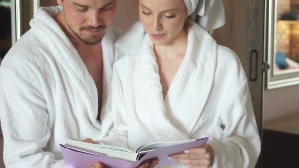 Happy Family Relaxes in Hotel, Dressed in White Robes