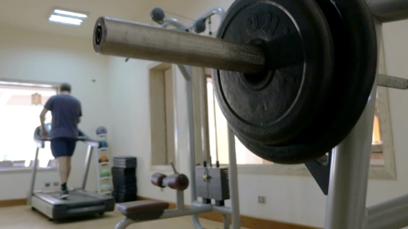 Sportsman Putting Disk Weight On The Barbell In